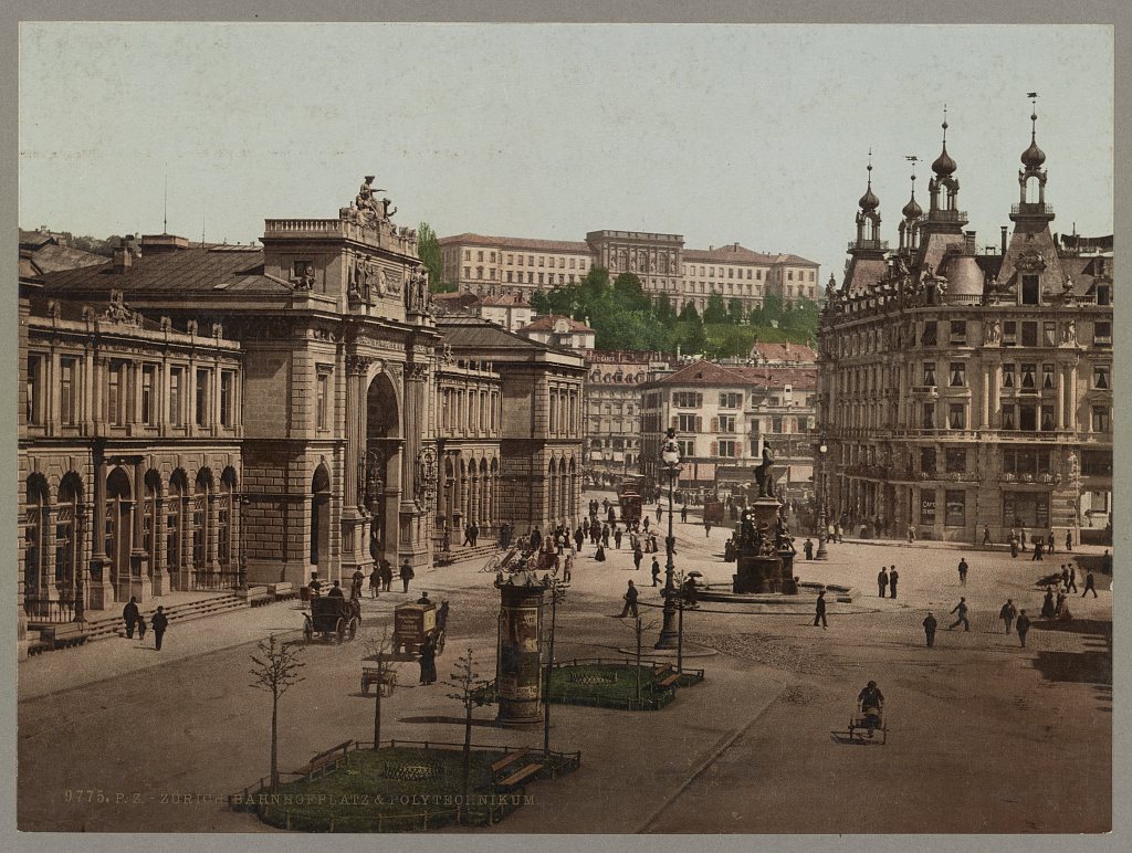 Colour photochrom of Zurich's Bahnhofplatz in the 1890s: the railway station on the left, a fountain and pedestrians in the square, and the long Polytechnikum building on the hill behind.