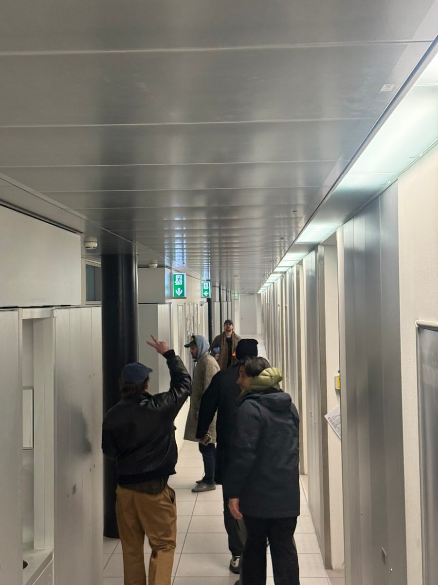 The founders walking down a long white corridor, one throwing a peace sign.